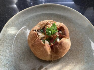 Keizerbroodje met ei, kastanje champignons, ontbijtspek, pijnboom pitjes en verse kruiden